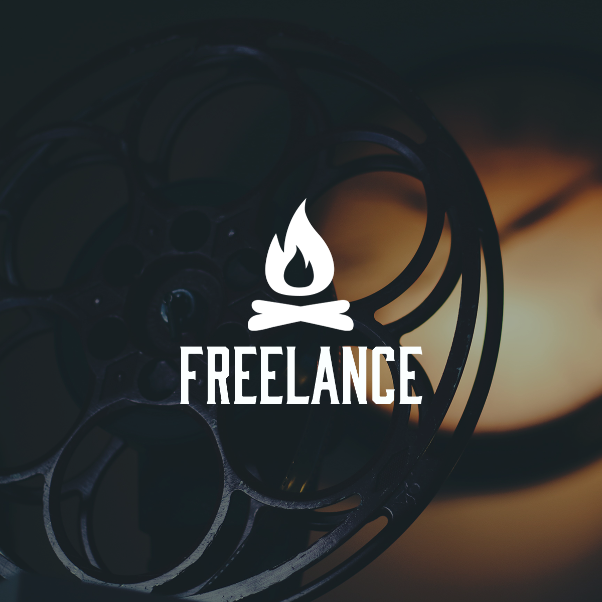 low-light image of a film reel with a logo of a campfire and the words freelance